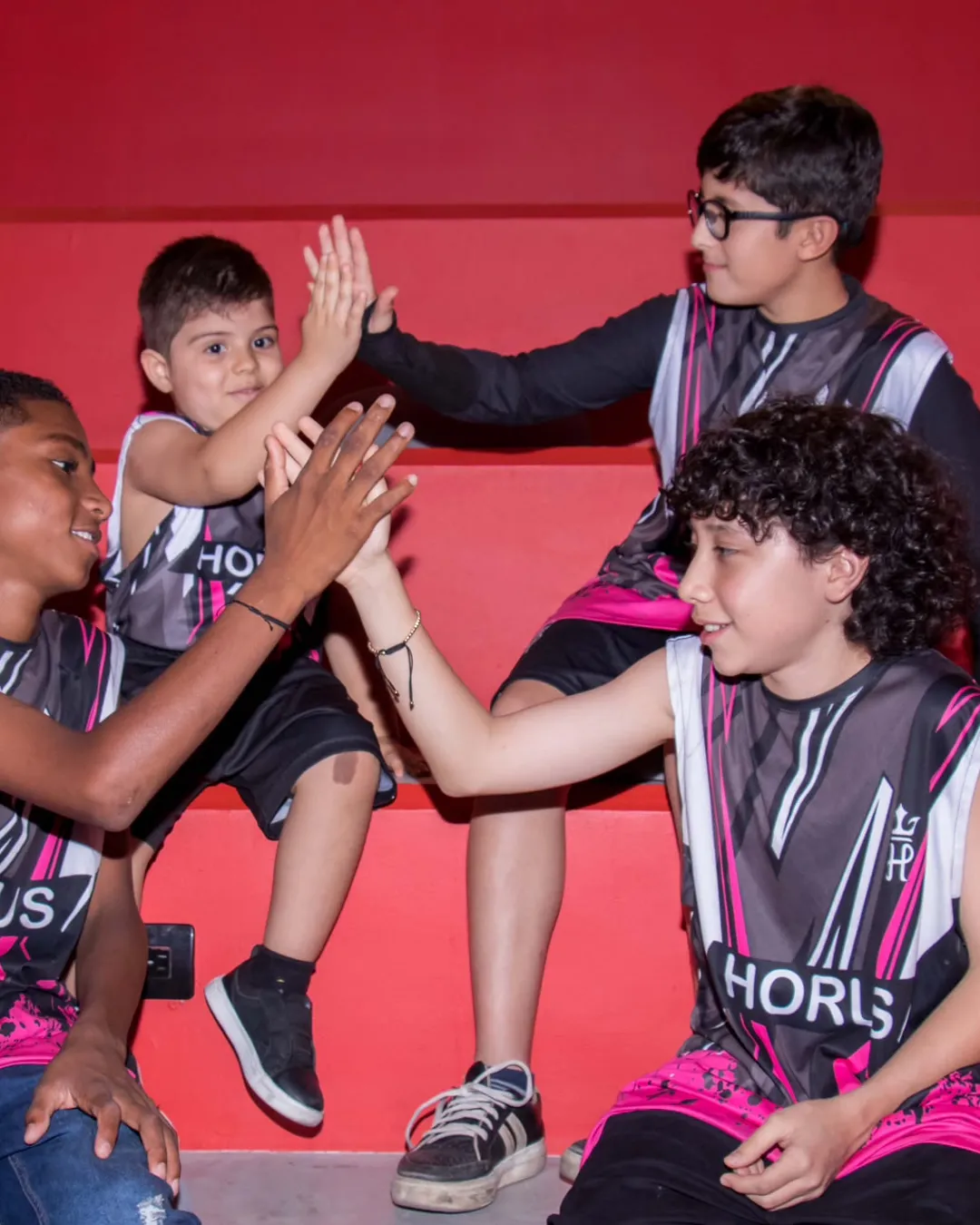 Deportistas juveniles chocan las manos con los uniformes de un club aliado de 11 Cracks.