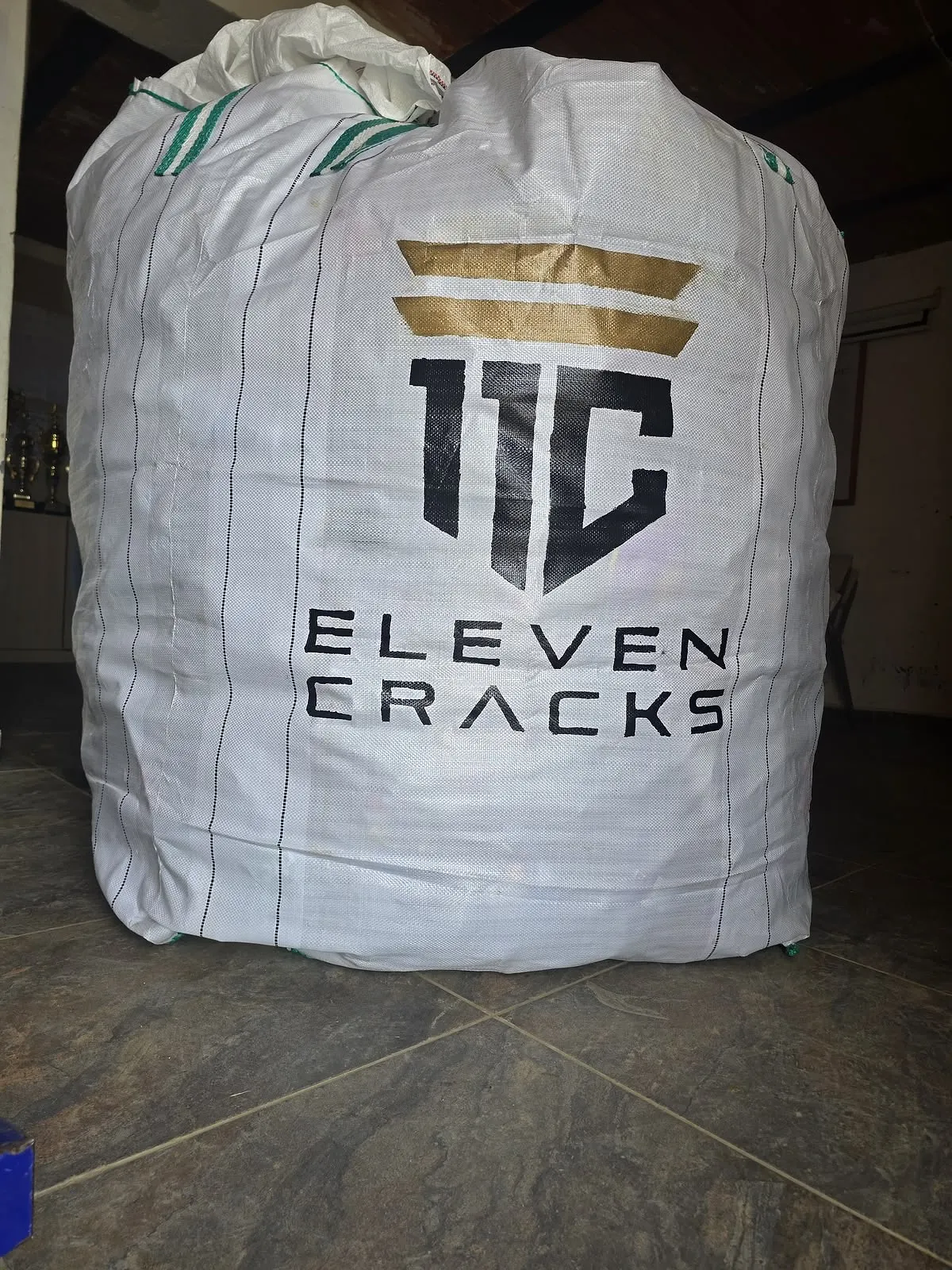 Un costal de recolección PET con el logo de 11 Cracks en la sala de trofeos de un club.