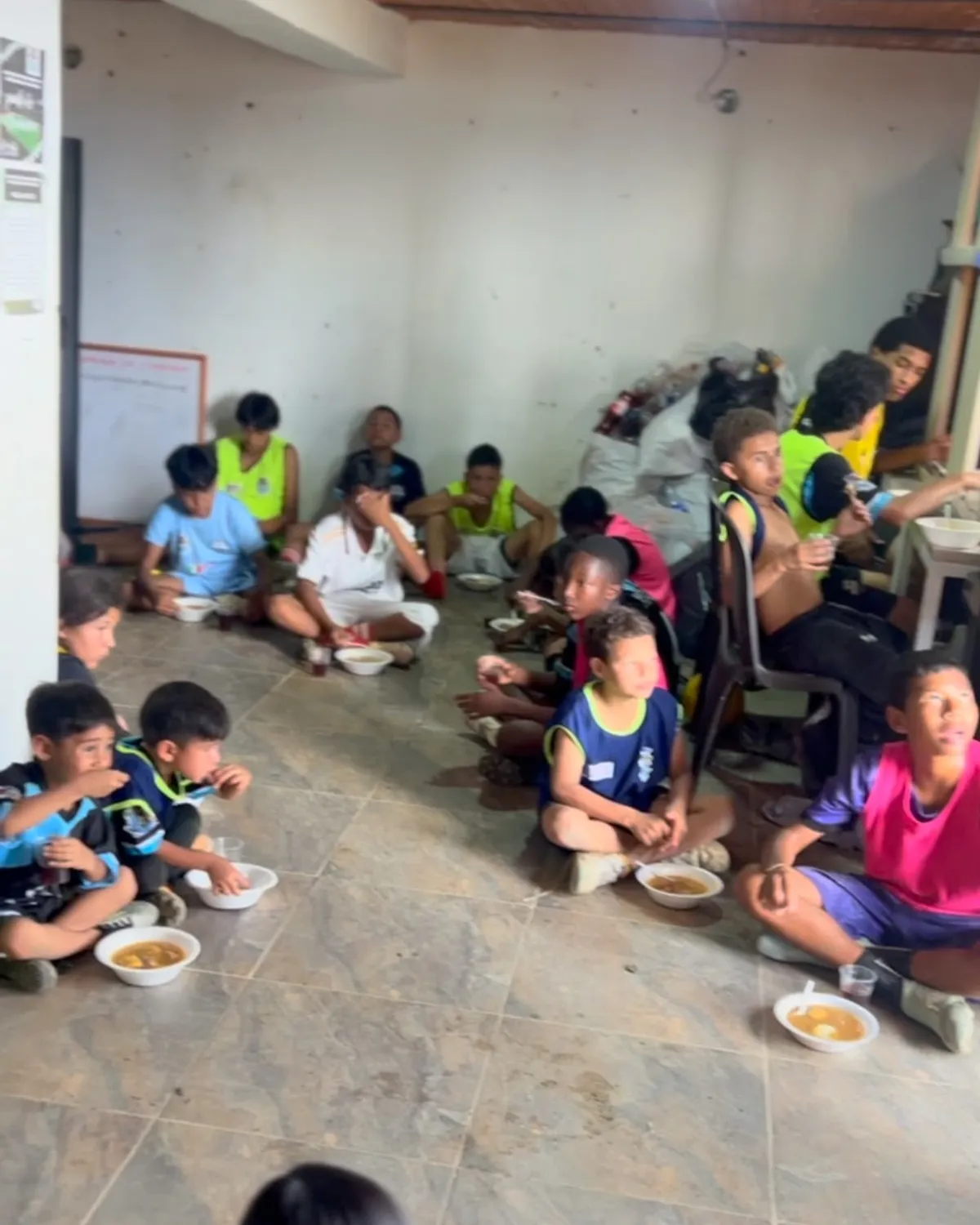 Niños de 11 Cracks comparten un momento de alimentación sentados en el piso, después de entrenar.