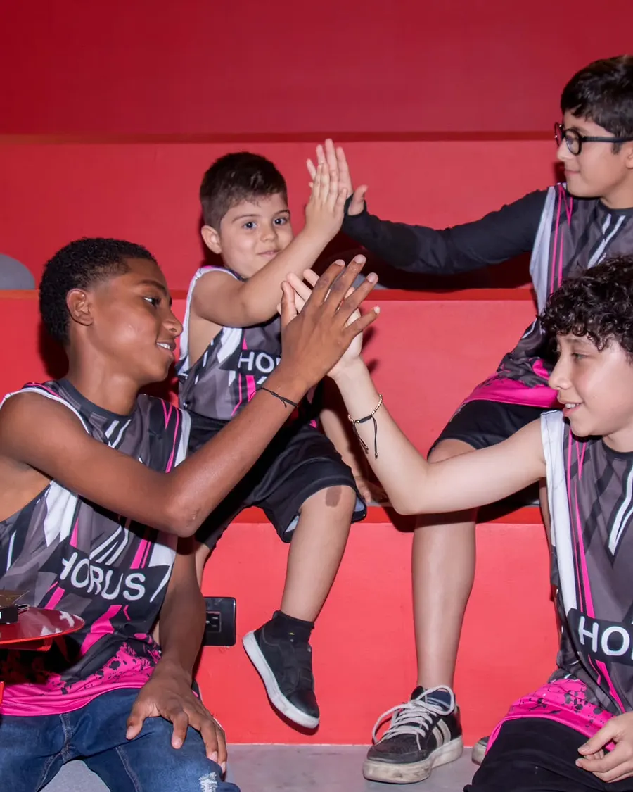 Un grupo de jóvenes deportistas se chocan las manos en celebración, en un gesto de comunidad.